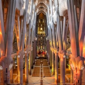 Interior of a grand cathedral with high, ornate columns, vibrant stained glass lighting, and symmetrical seating arrangements.